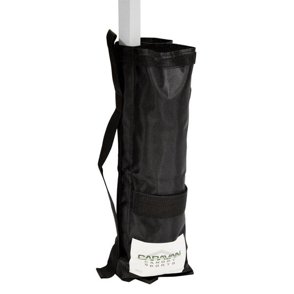 A black Caravan Canopy weight bag with a white strap.