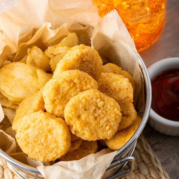 A bag of Tyson Breaded Chicken Nuggets in front of a bucket of ketchup.