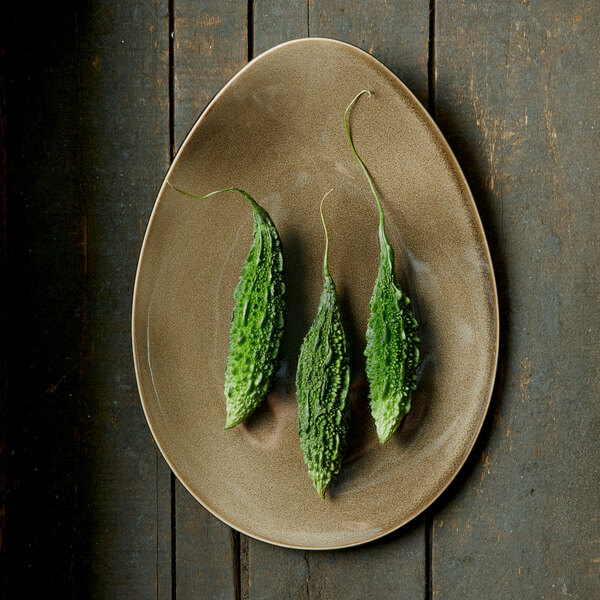 Oneida Rustic porcelain plate with green pods on it.