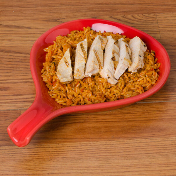 A red plate with rice and chicken pieces on it.