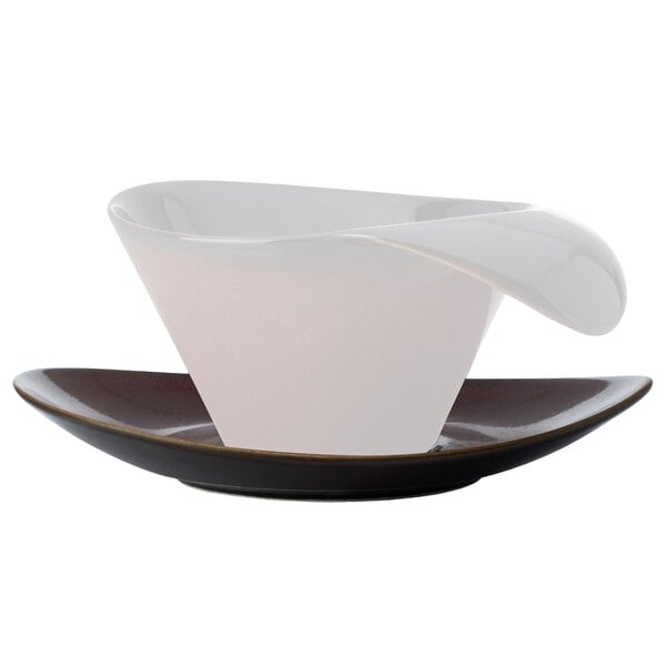A white Oneida Rustic Crimson porcelain saucer with a black cup on a white plate.