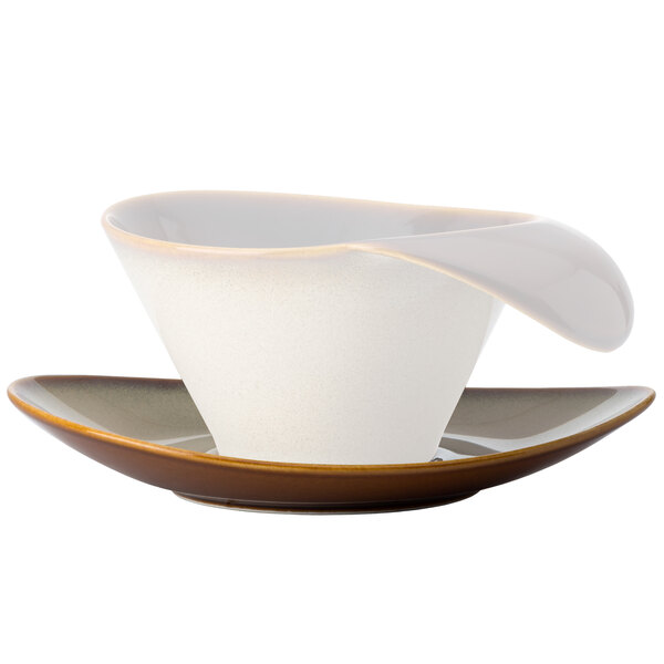 A white and brown Oneida Rustic Sama porcelain oval coupe saucer with a white bowl on it.