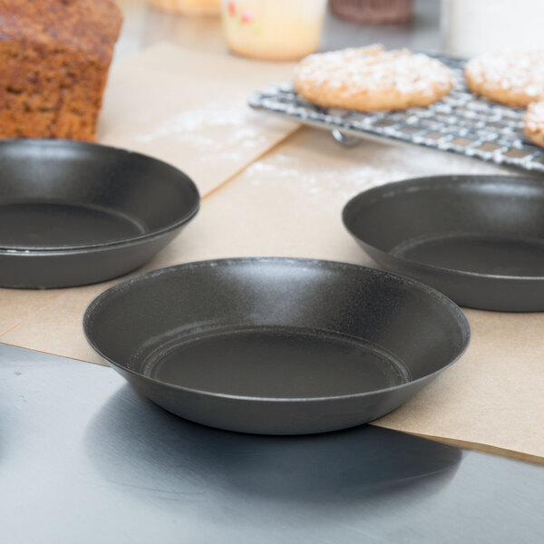 Three Matfer Bourgeat tartlet pans on a table.
