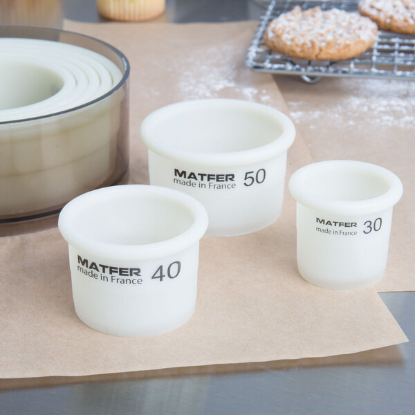 A Matfer Bourgeat white container with black text holding an 8-piece Exoglass round pastry cutter set.