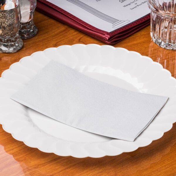 A white plate with a Hoffmaster Dove Gray paper napkin on it.