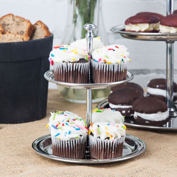 An American Metalcraft stainless steel two tier display stand with cupcakes and cookies on it.