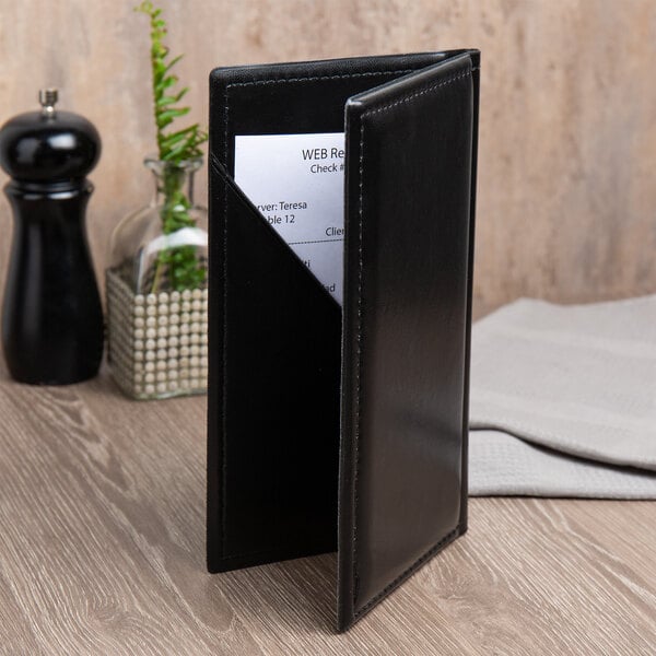 A black leather holder with a piece of paper inside.
