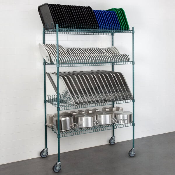 A Regency wire drying rack with green epoxy shelves holding several pans and plates.