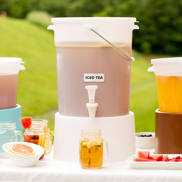 A Choice white beverage dispenser with a white base filled with a pink drink and orange slices.