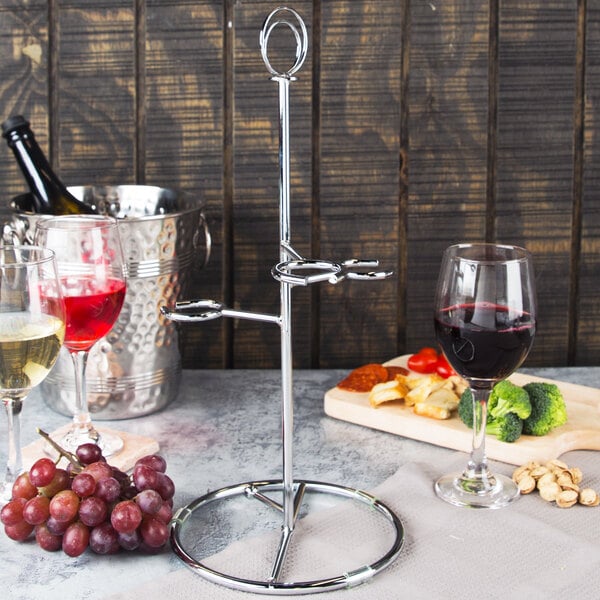 A Franmara steel wine flight stand holding wine glasses on a table.