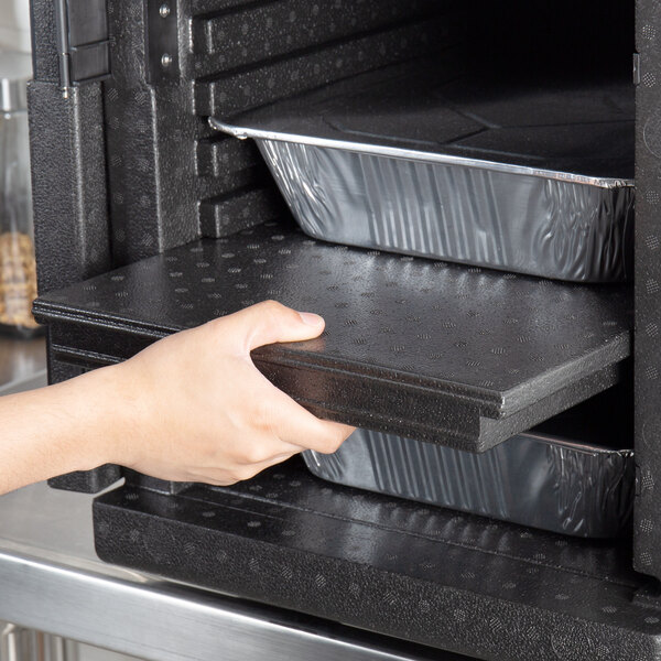 A hand opening a black Cambro ThermoBarrier for EPP Front Loaders.