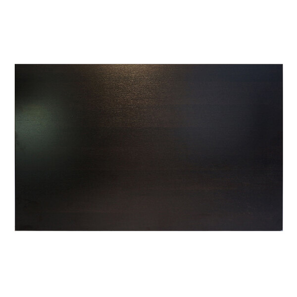 A dark wood rectangular table top with light shining on it.