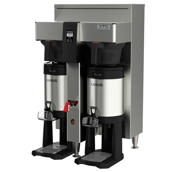 Two Fetco stainless steel commercial automatic coffee brewers on a table.