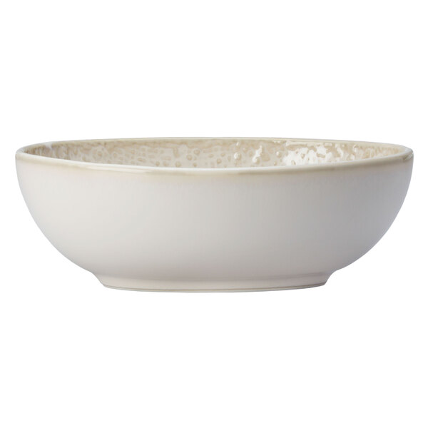 An Oneida Knit oval porcelain bowl with a white rim with a speckled design.