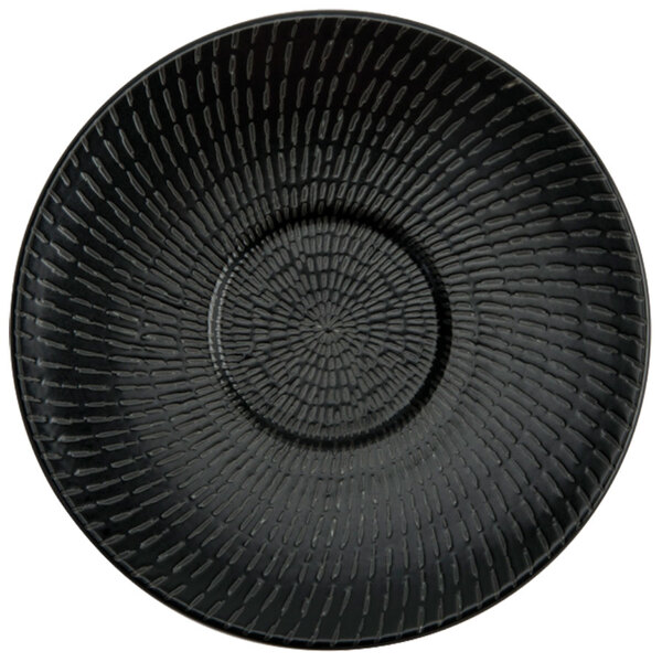 A close up of a black saucer with a pattern on it.