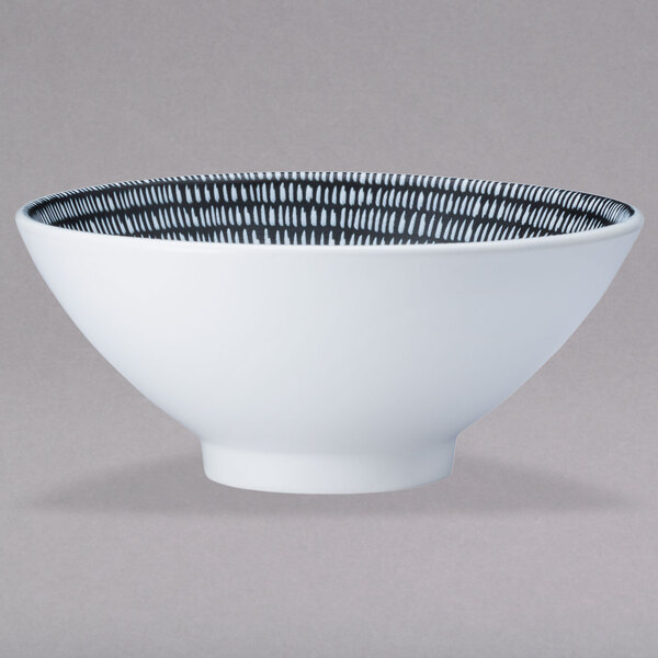 A white Oneida porcelain pedestal bowl with a black and white pattern.
