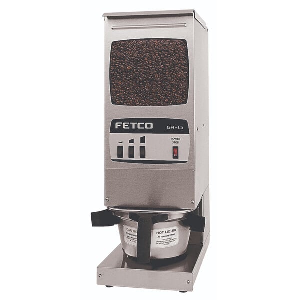 A Fetco commercial coffee grinder with a coffee bean on top.