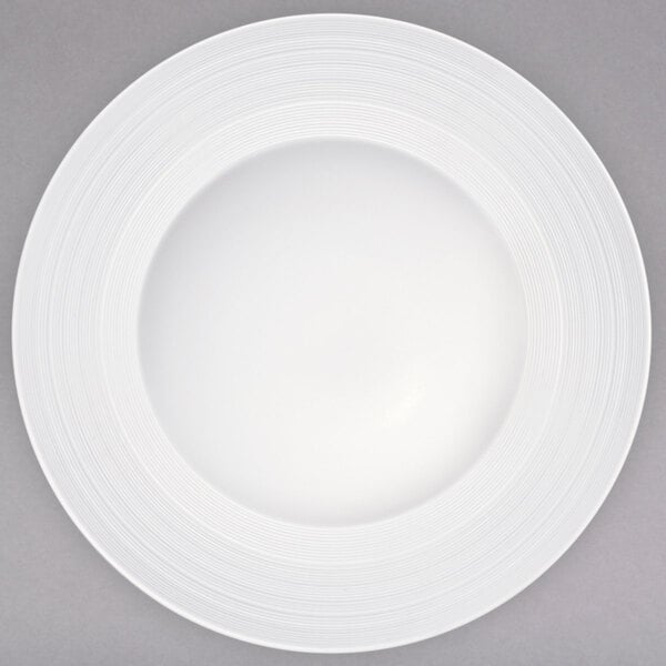 A white porcelain rim soup bowl with a circular pattern on the rim.