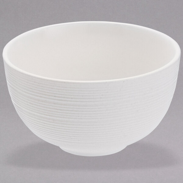 A Oneida warm white porcelain bowl with a textured surface and thin rim on a white background.