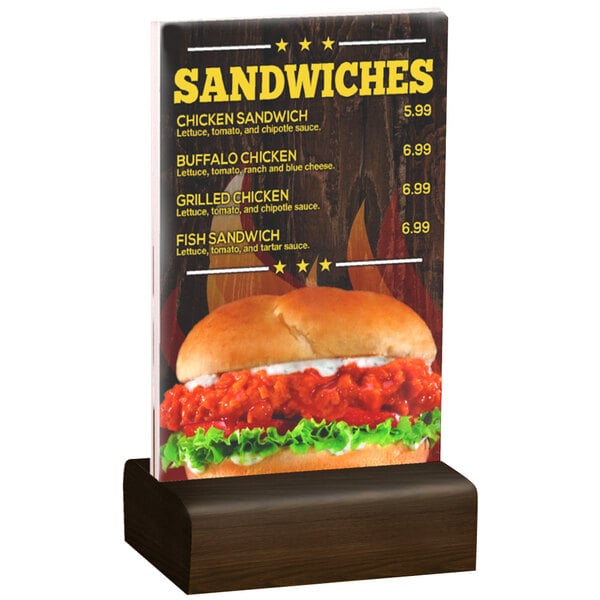 A Menu Solutions clear acrylic table tent with a walnut wood base on a table with a menu sign displaying a sandwich.