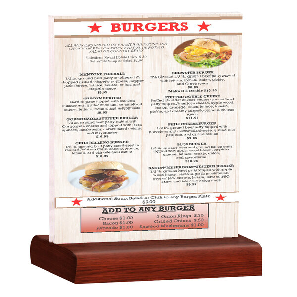 A Menu Solutions clear acrylic table tent with mahogany wood base holding a menu on a table with a burger on it.