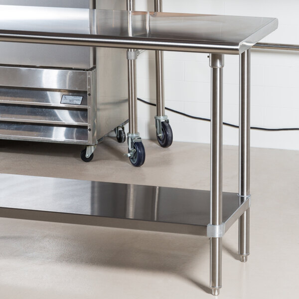 An Advance Tabco stainless steel work table with undershelf and wheels.