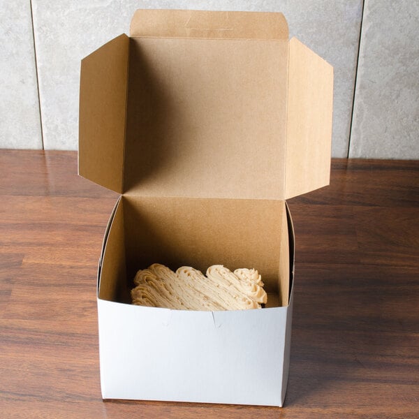 A white 5 1/2" x 5 1/2" bakery box with food inside.