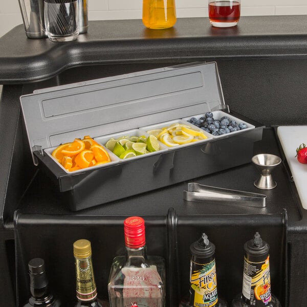 A Choice 4-compartment condiment bar with fruit and drink containers on a counter.