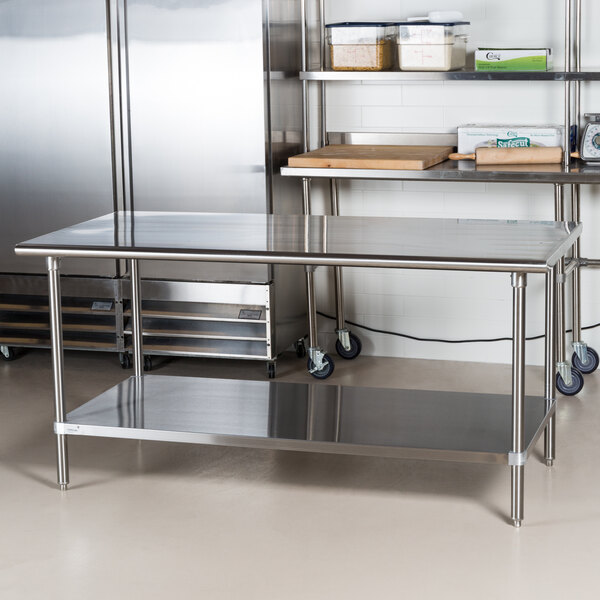 An Advance Tabco stainless steel work table with undershelf in a professional kitchen.