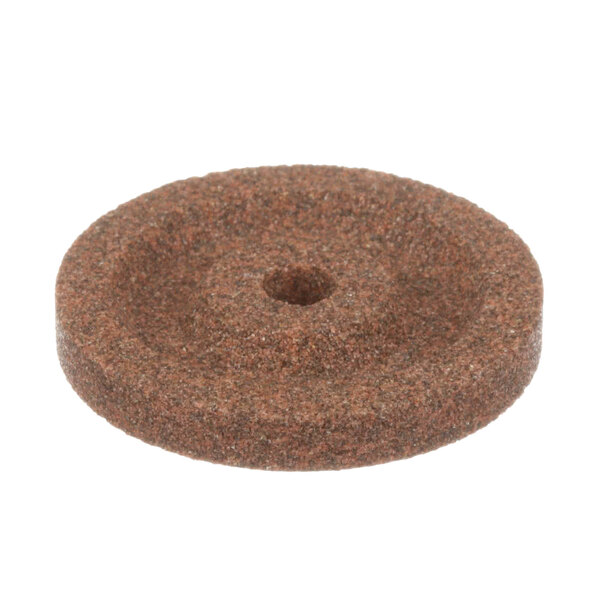 A brown circular stone with a hole in it.