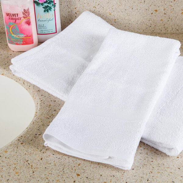Two white Oxford open end hand towels on a counter.