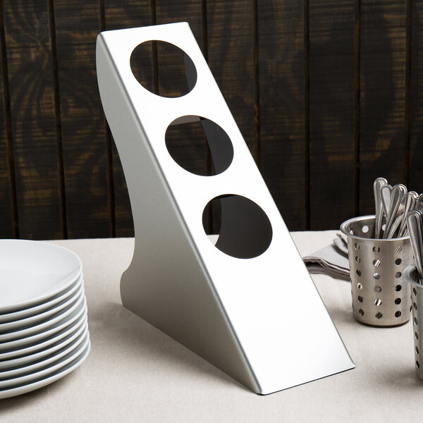 A silver metal Cal-Mil vertical flatware display with circles on it.