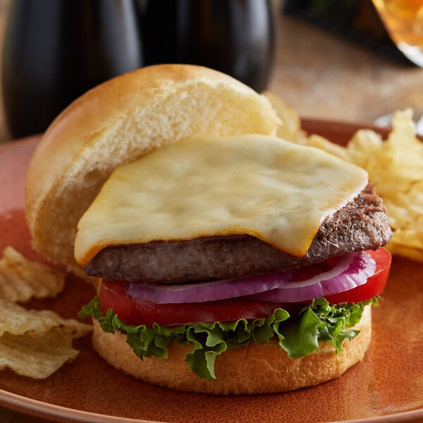 A cheeseburger with Great Lakes Muenster cheese, lettuce, and tomato on a bun.