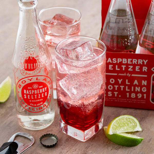 A Boylan Bottling Co. raspberry seltzer bottle next to a glass of pink liquid with ice.