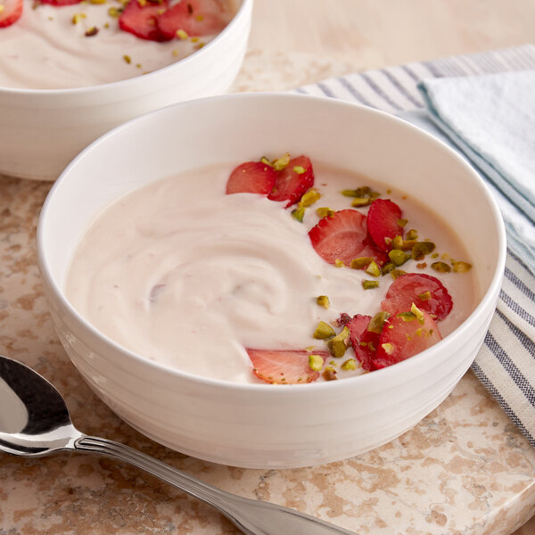 A bowl of Pequea Valley Farm strawberry yogurt with strawberries and pistachios.