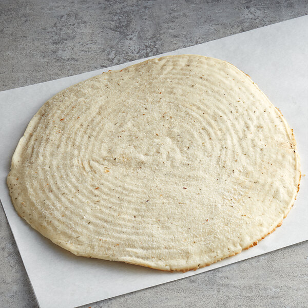 A round white Venice Bakery gluten-free vegan pizza crust on a white surface.