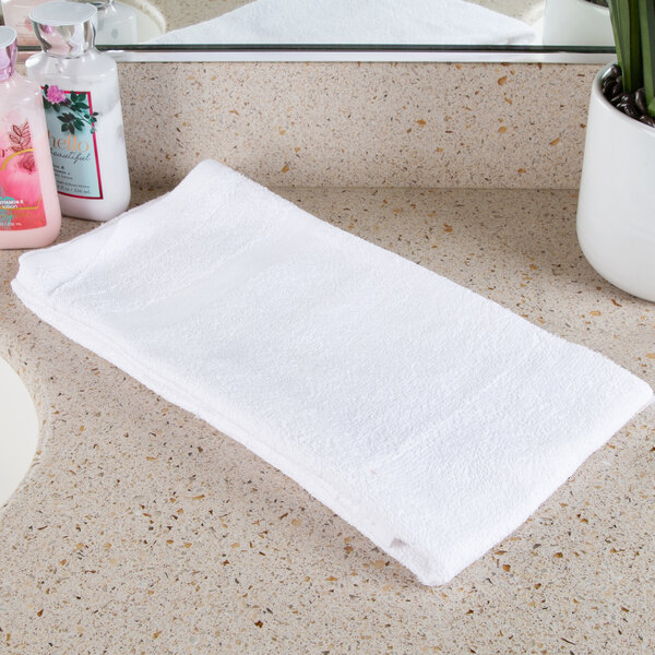 An open pack of Oxford white bath towels on a white counter.