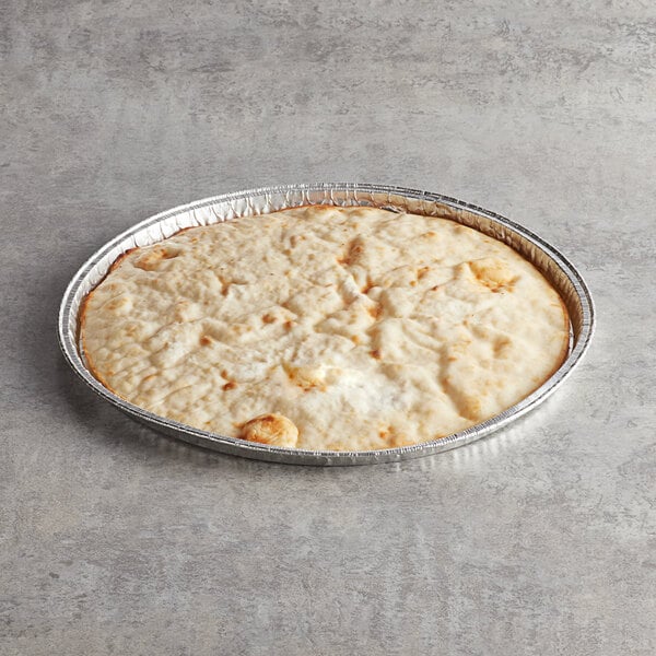A round white Venice Bakery gluten-free vegan pizza crust in a tin pan.