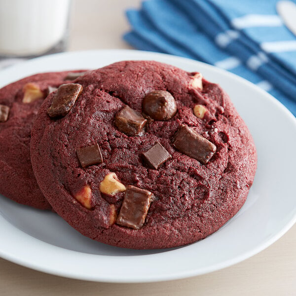 A red David's Cookies preformed red velvet cookie with chocolate chunks on top.