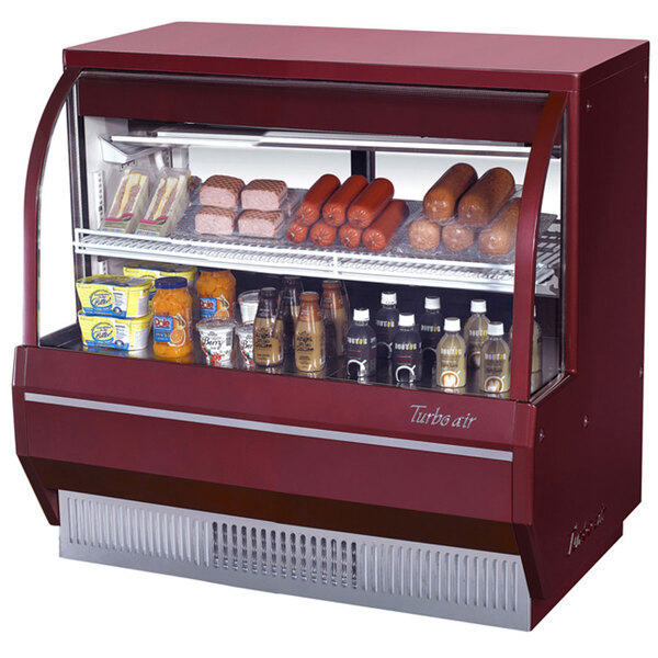 A red Turbo Air refrigerated deli case filled with food items.