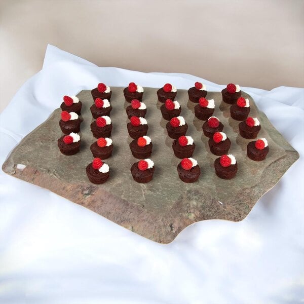 A GET Stone-Mel Melamine display tray of chocolate covered strawberries on a stone surface.