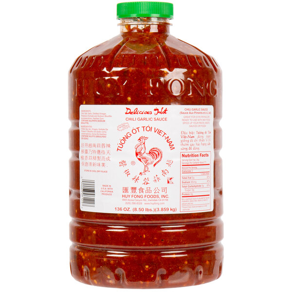 A large jar of Huy Fong Chili Garlic Sauce with a red lid.