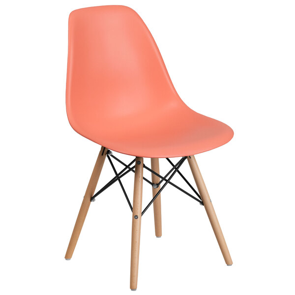 A Flash Furniture peach plastic chair with wood legs.