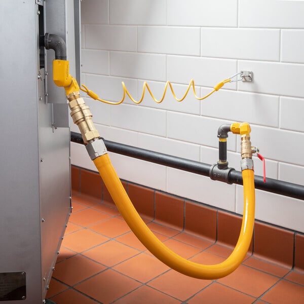 A yellow Regency gas hose connected to a metal pipe.