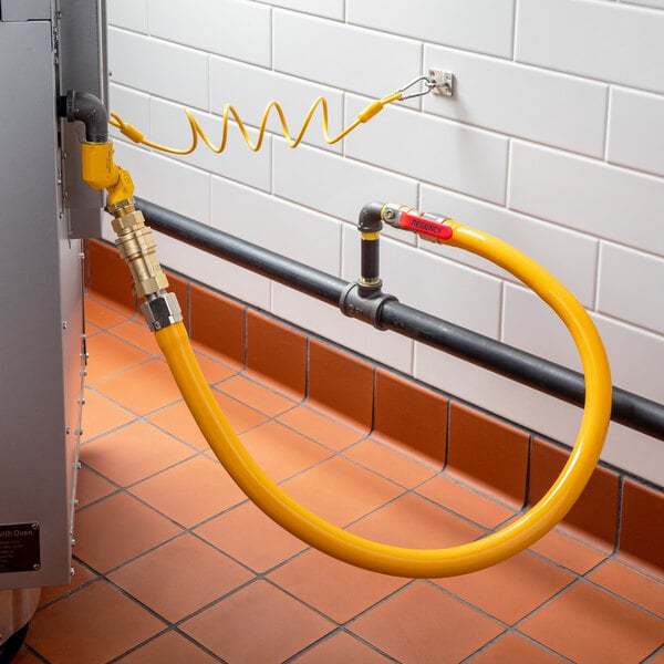 A yellow hose attached to a metal pipe with black connectors.
