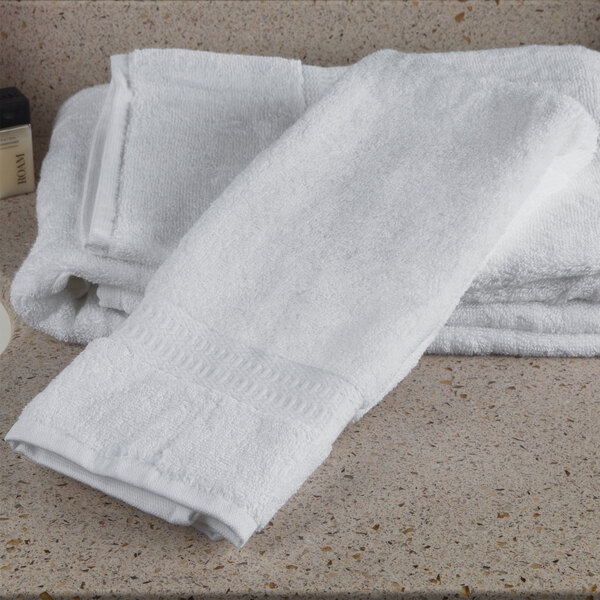 A stack of white Oxford Reserve hand towels on a counter.