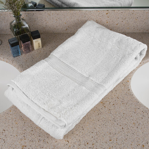 An Oxford Vicenza Bianco 100% Ringspun Combed Cotton white towel with a dobby border on a white counter.