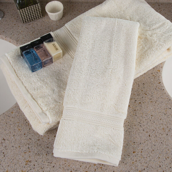 A group of Oxford Vicenza Avorio hand towels with a dobby border on a counter top.