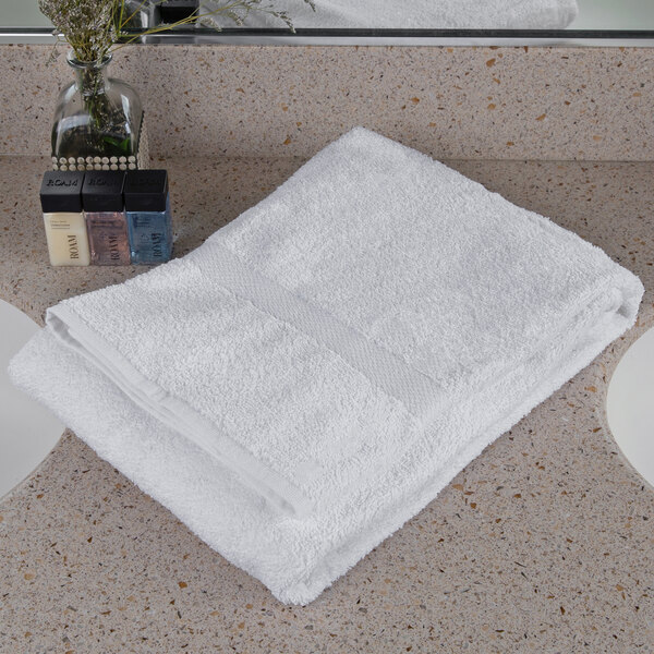 An Oxford Regale white towel with a dobby border on a white counter.