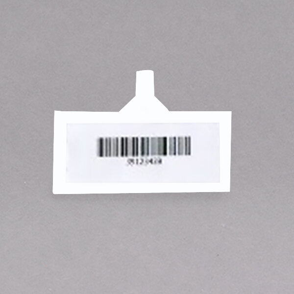 A white rectangular tag with a barcode on a gray surface.
